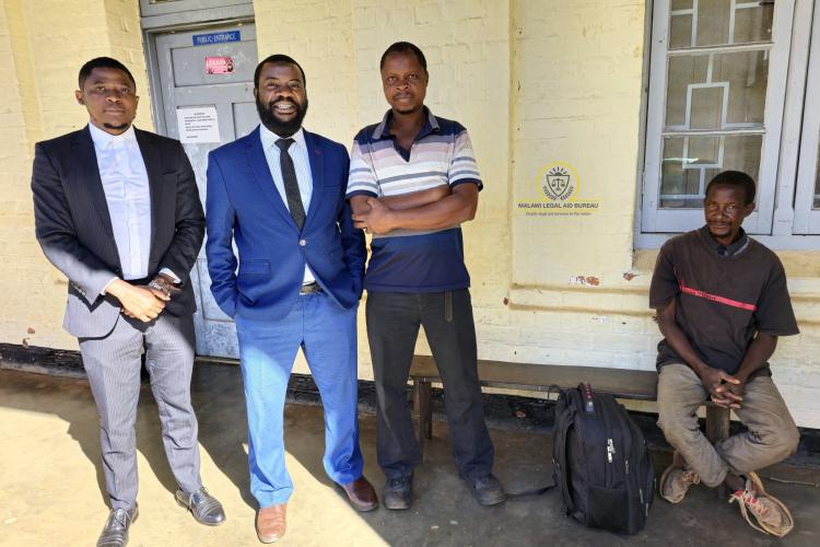SLAA Mwale and AD Ndeketa (in suit) pose with the clients